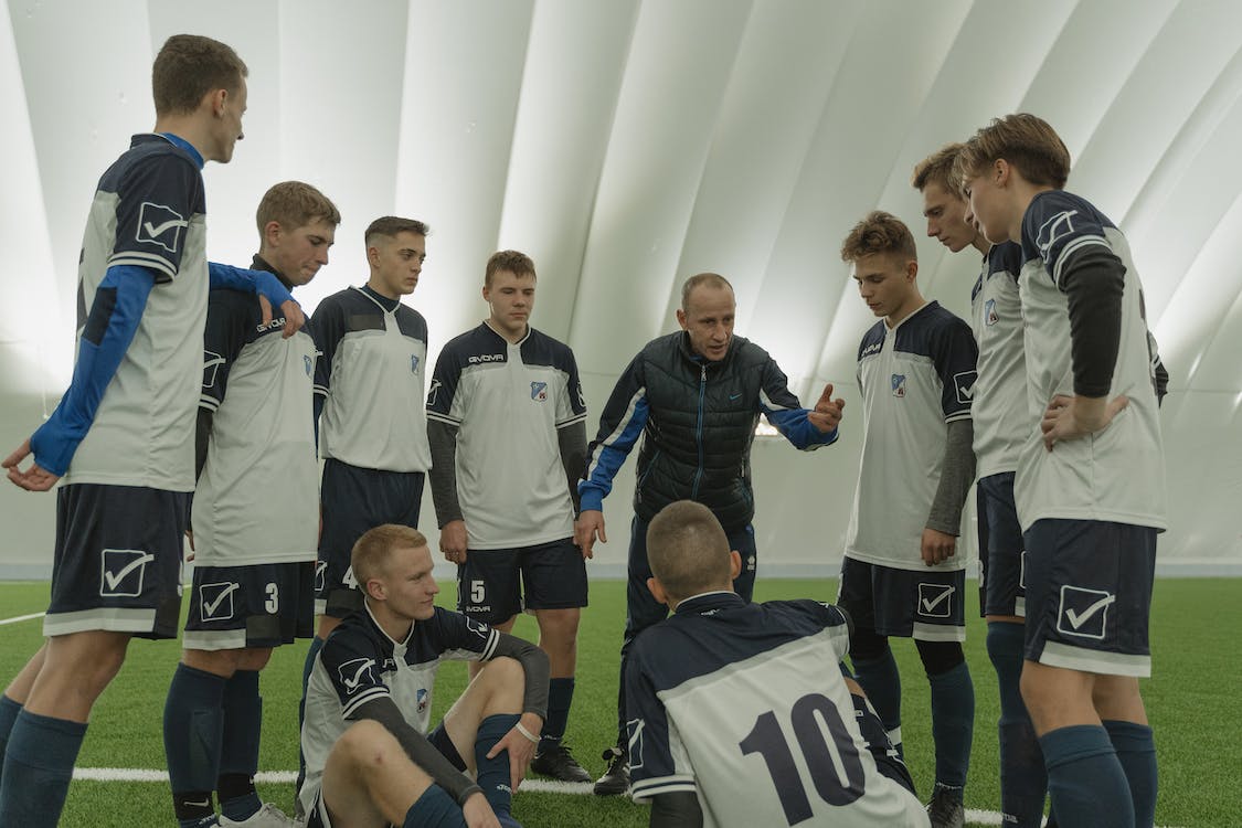 Jogadores conversando com o treinador em círculo